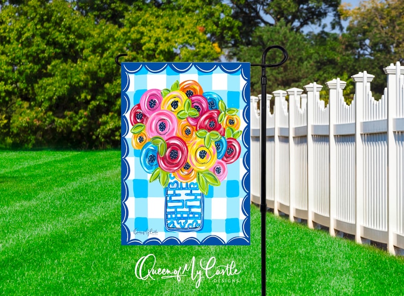 K&ouml;nnte beinhalten: Eine blaue und wei&szlig;e Gingham-Gartenflagge mit einem bunten Blumenstrau&szlig; in einer blauen Vase. Die Flagge hat einen gewellten Rand und den Text "Queen of My Castle Designs" unten.