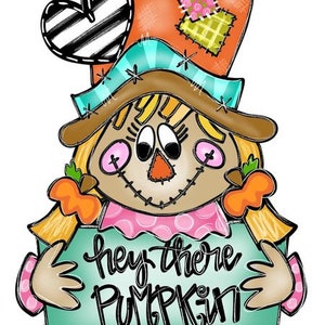 May include: A whimsical scarecrow with a heart-shaped hat and a sign that says "Hey there Pumpkin". The scarecrow is wearing a pink dress and has a brown face with pink cheeks.
