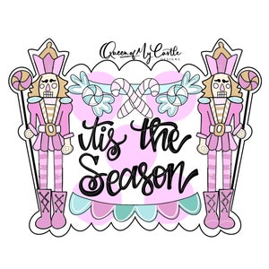 Puede incluir: Un diseño navideño rosa y blanco con dos figuras de cascanueces que sostienen bastones de caramelo y una pancarta que dice "'tis the season".
