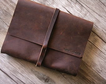 May include: A brown leather portfolio with a strap closure and the text "Haven Conference" embossed on the front.