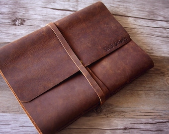 May include: A brown leather-bound journal with a strap closure and the text "Smith & Griffin" embossed on the front cover.
