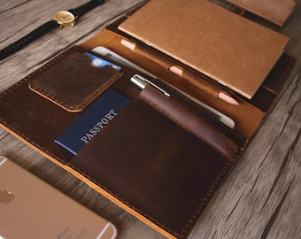 May include: A brown leather travel wallet with a passport holder, pen holder, and card slots. The wallet is open and has a notebook inside.
