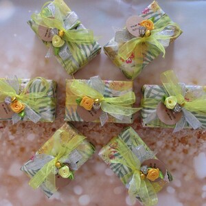 May include: Six small gift boxes wrapped in yellow and green patterned paper with yellow ribbon and a small flower embellishment. Each box has a small brown tag with the text "Thank you for being you".