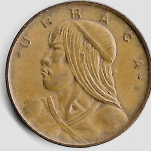 May include: A bronze coin featuring a profile of a person wearing a hat and with long hair. The coin has the word "URRACA" around the edge. The coin has a worn appearance.