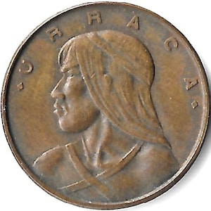 May include: A bronze-colored coin featuring a profile of a person with long hair. The coin has raised lettering around the edge, with the letters "BRACA" visible. The design is detailed and shows the person's facial features.