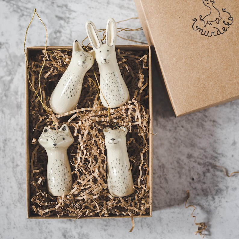 Christmas tree wild animals decoration set of four. Fox, bear, raccoon, hare ceramic ornaments hanging from a gold string.