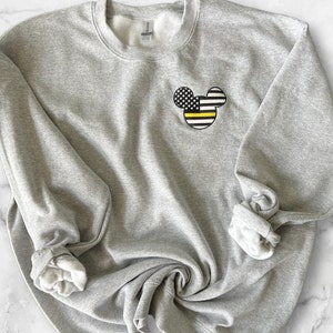 May include: Gray sweatshirt with a black and yellow American flag Mickey Mouse design on the front.