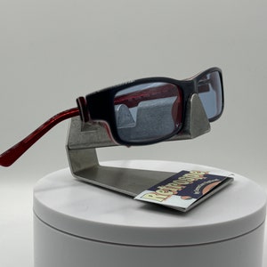 May include: Red and black sunglasses with a silver stand and a card that says "Retrospecs" with a retro-style font.