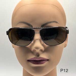 May include: Black aviator sunglasses with brown gradient lenses. The sunglasses have a double bridge and a metal frame. The text "P12" is visible in the lower right corner.