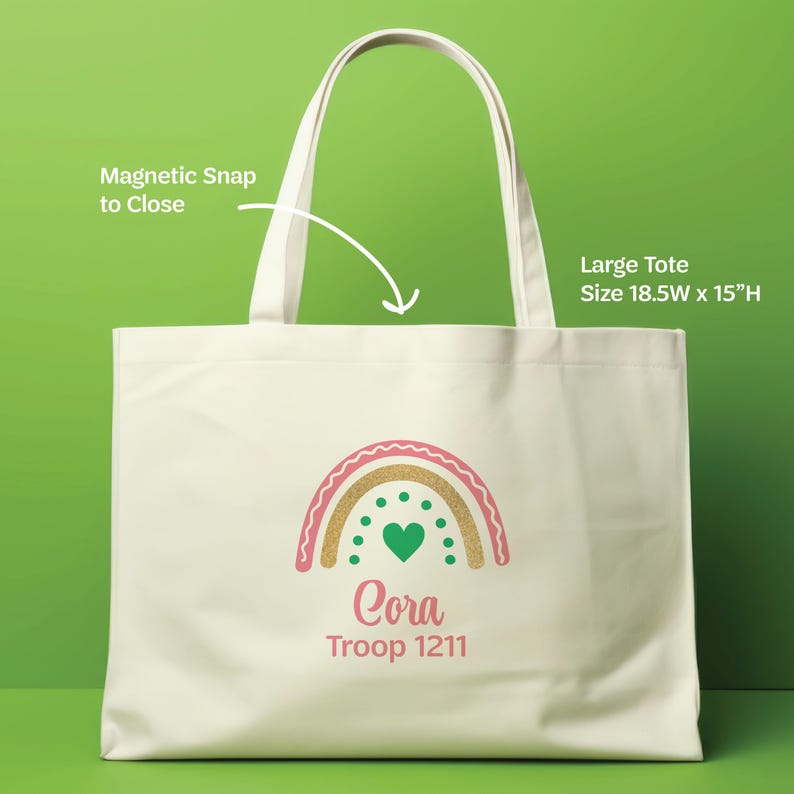 May include: A large off-white tote bag with two handles and a magnetic snap closure. The front features a graphic of a rainbow with a green heart and the text "Cora Troop 1211". The bag measures 18.5 inches wide by 15 inches high.