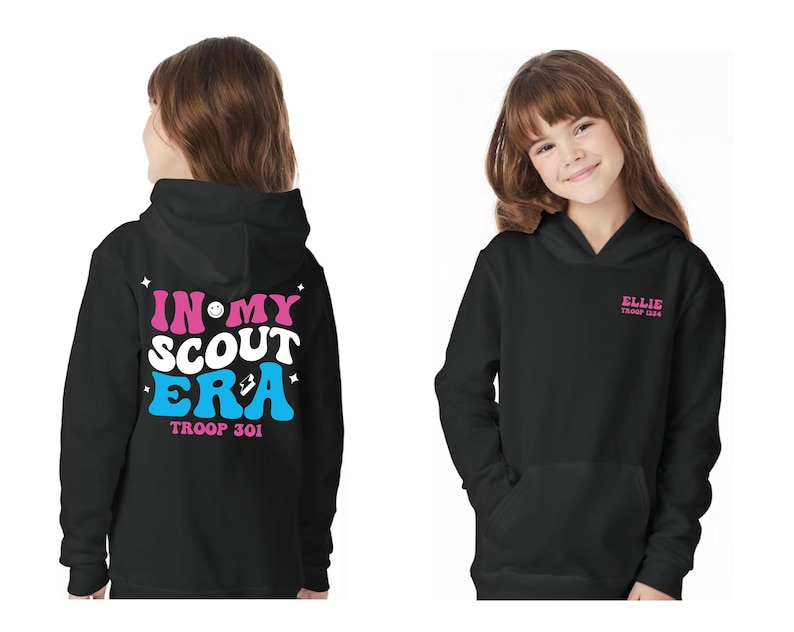 May include: Black hooded sweatshirt with a pink and blue graphic on the back that says "In My Scout Era" with a smiley face and a patch. The text "Troop 301" is below the graphic. The front of the sweatshirt has pink text that says "Ellie Troop 1234".
