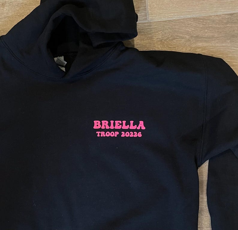 May include: Black hooded sweatshirt with pink lettering that reads "Briella Troop 20226".