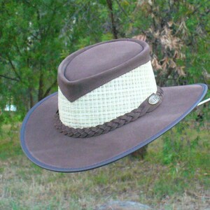 Peut inclure: Un chapeau outback en cuir marron avec une couronne en paille tress&eacute;e et une bande en cuir. Le chapeau a une bordure en cuir marron et une petite &eacute;tiquette m&eacute;tallique avec le texte "B.L.A.C."