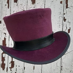 May include: A purple top hat with a black band around the crown. The hat is made of felt and has a wide brim.