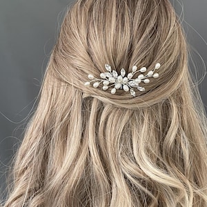 May include: A silver hair comb with pearl and crystal accents. The comb is designed in a delicate, floral pattern.