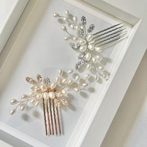 May include: Two silver and gold hair combs with pearl and crystal embellishments. The combs are displayed on a white background.