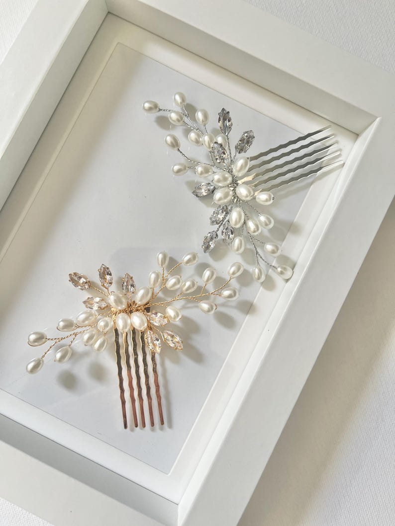 May include: Two silver and gold hair combs with pearl and crystal embellishments. The combs are displayed on a white background.