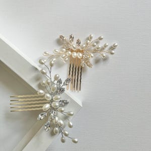 May include: Two gold and silver hair combs with pearl and crystal embellishments. The combs are on a white surface.
