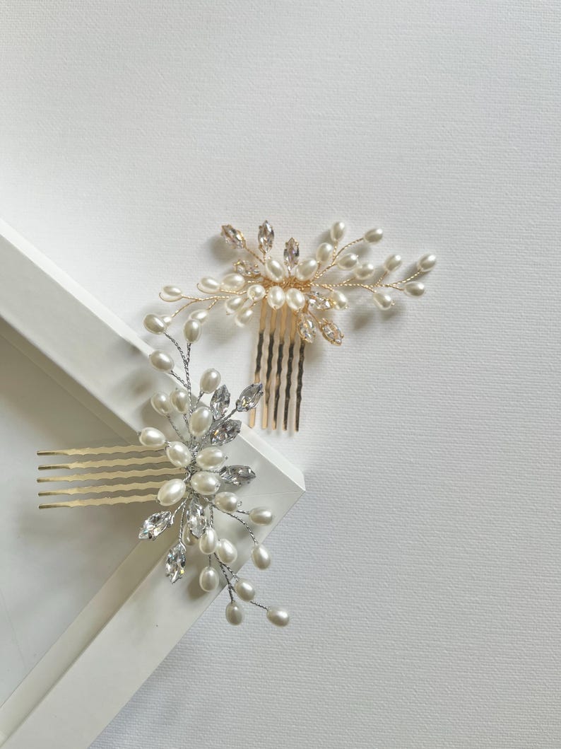 May include: Two gold and silver hair combs with pearl and crystal embellishments. The combs are on a white surface.