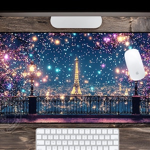 May include: A rectangular mousepad featuring a nighttime cityscape of Paris with the Eiffel Tower illuminated in gold. The design includes a starry sky, trees with colorful lights, and a black wrought-iron fence. A white mouse and keyboard are visible.