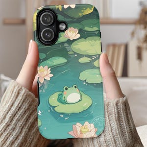 May include: A rectangular smartphone case featuring a printed illustration of a small green frog sitting on a lily pad in a pond. The design includes several light pink water lily flowers and various green lily pads floating on teal water.