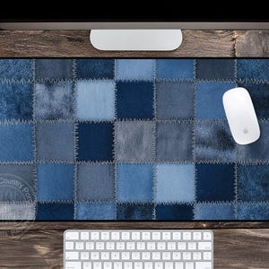 May include: A rectangular mousepad with a patchwork denim design in various shades of blue. The mousepad has a black border and a white mouse is positioned on the right side. A white keyboard is visible at the bottom.