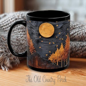 May include: Black ceramic mug featuring a detailed illustration of a nighttime forest scene with a full moon and autumn trees. The mug has a black handle and the text "The Old Country Porch".