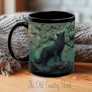 May include: Black ceramic mug featuring a detailed relief of a howling wolf against a backdrop of a tree and foliage. The mug has a black handle and rim, with the text "The Old Country Porch".