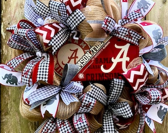 Può includere: Una ghirlanda decorativa con il logo e i colori dell'Università dell'Alabama Crimson Tide. La ghirlanda include un mix di juta, nastri rossi, bianchi e neri, con dettagli a pied de poule ed elefanti. La ghirlanda ha un aspetto rustico e fatto a mano.