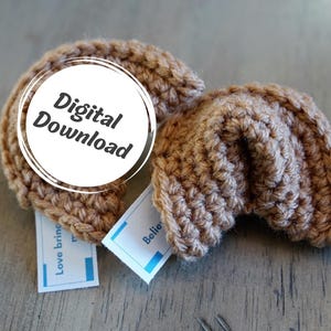 Könnte beinhalten: Zwei gehäkelte Glückskeks-Spielzeuge in hellbrauner Farbe. Der Text "Digitaler Download" ist auf einem weißen Kreis sichtbar.