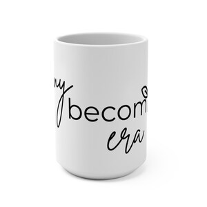 May include: White ceramic mug with the handwritten text "my becoming era" in black cursive script. The mug is cylindrical and has a simple, clean design, suitable for coffee or tea.
