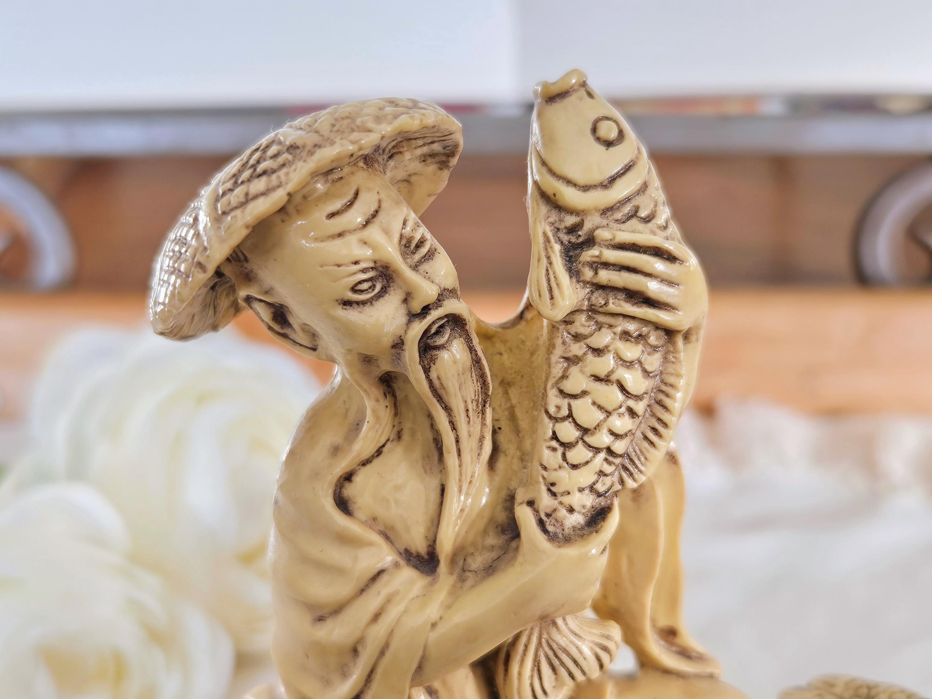 木製の台に置かれたヴィンテージの中国漁師の樹脂製置物、ボートで釣り