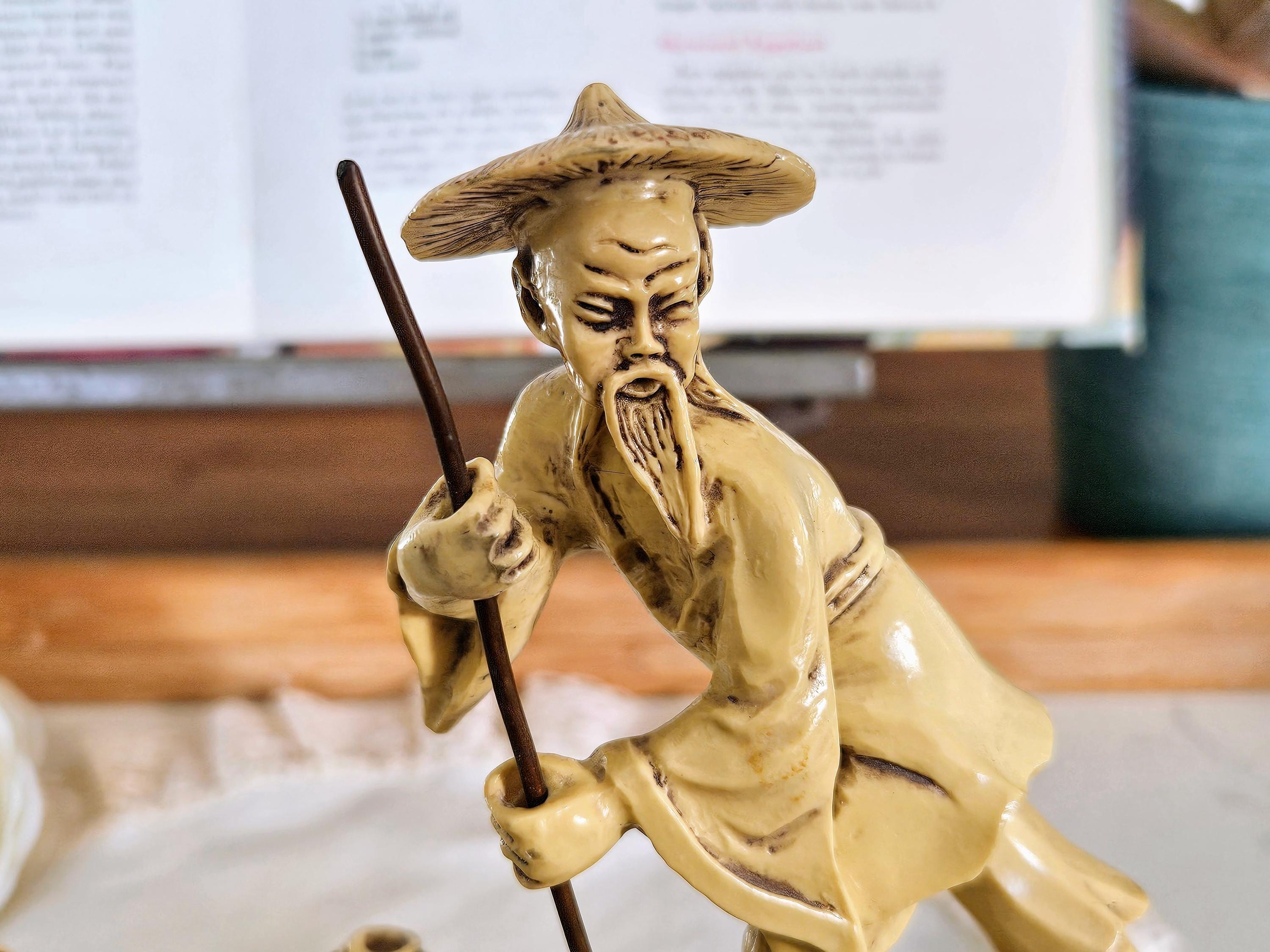 木製の台に置かれたヴィンテージの中国漁師の樹脂製置物、ボートで釣り