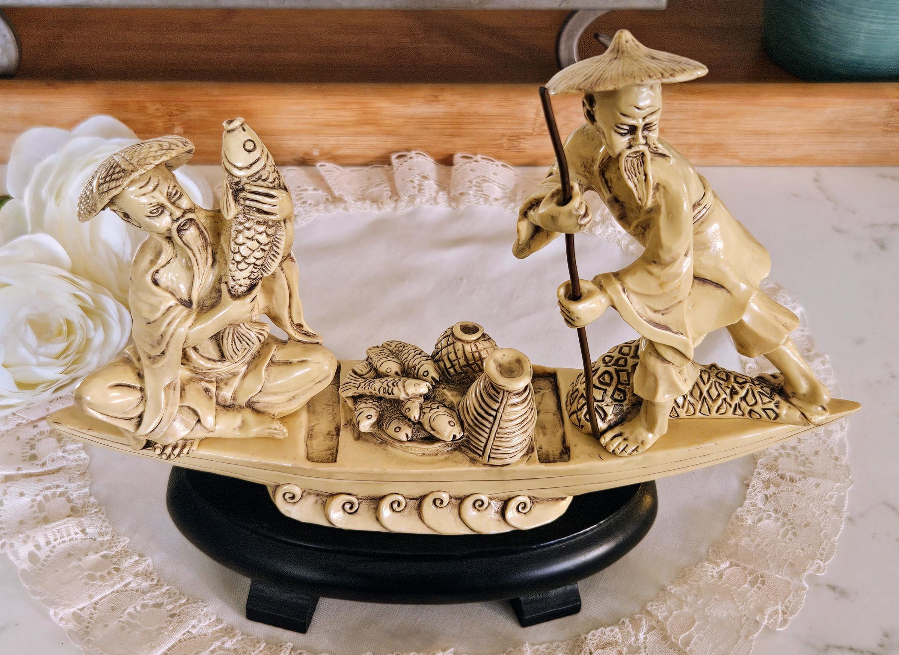 木製の台に置かれたヴィンテージの中国漁師の樹脂製置物、ボートで釣り