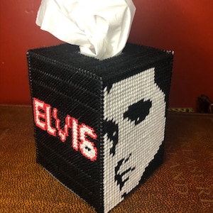 Könnte beinhalten: Schwarzer und weißer Taschentuchbox-Bezug mit einem Porträt von Elvis Presley und dem Wort "ELVIS" in roten Buchstaben.