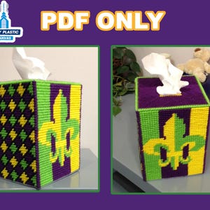 Può includere: Un copri scatola di fazzoletti in tela plastica viola, verde e gialla con un motivo a giglio. Il copri scatola è realizzato in tela plastica ed è un progetto di artigianato.