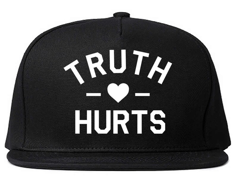 May include: Black and white baseball cap with the text "TRUTH - HEART - HURTS" on the front.