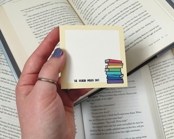 Pila di libri arcobaleno su un blocco note Post It -  Italia