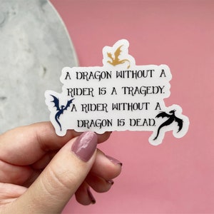 May include: A white sticker with black text and three black dragon silhouettes. The text reads: "A dragon without a rider is a tragedy. A rider without a dragon is dead."