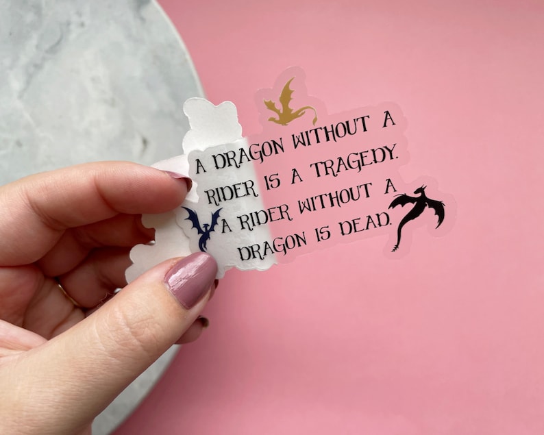 May include: A clear sticker with a black and white dragon silhouette and the text "A dragon without a rider is a tragedy. A rider without a dragon is dead."