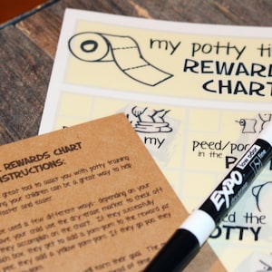 May include: A brown paper chart with the text "My Potty Time Rewards Chart and Jar Instructions" and a white dry-erase marker with the text "Expo Low Odor Dry Erase Fine" on top of a white chart with the text "My Potty Time Rewards Chart".