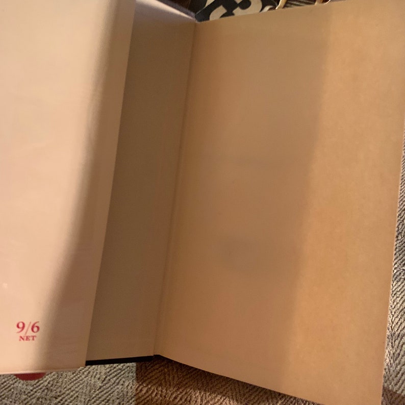 Puede incluir: Primer plano del interior de un libro con una p&aacute;gina en blanco y el n&uacute;mero "9/6" escrito en rojo en la esquina inferior izquierda de la p&aacute;gina.