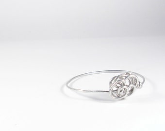 Aluminum wire bracelet with stylized flower. Silver color bangle.