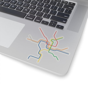 May include: A colorful sticker featuring a stylized map design with lines in red, orange, yellow, green, and blue. The sticker is placed on a laptop, showcasing a modern and tech-savvy aesthetic. The map design is abstract and geometric.