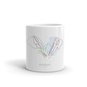 Könnte beinhalten: Weiße Keramiktasse mit einer schwarzen und weißen Umrandung der Skipisten am Windham Mountain in New York. Der Text "Windham" und "New York" ist in Grau unterhalb der Skipistenkarte gedruckt.