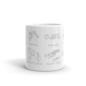May include: White ceramic mug with a design of ski resort trail maps. The maps are labeled "Heavenly", "Kirkwood", "Sierra At Tahoe", and "Squaw Valley".