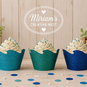 May include: Three cupcakes with white frosting and blue sprinkles, each in a glittery scalloped cupcake wrapper in shades of teal, green, and blue. The text "Miriam's CREATIVE NEST" is centered above the cupcakes with a decorative oval border.