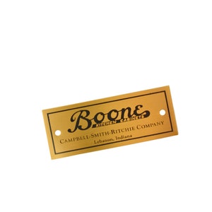 May include: A gold metal plaque with black text that reads "Boone Kitchen Cabinets Campbell-Smith-Ritchie Company Lebanon, Indiana".