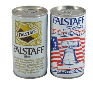 May include: Two vintage Falstaff beer cans. One can features a gold and brown logo with text. The other can has a red, white, and blue design with the text "Falstaff Salutes U.S.A. 1776-1976 Bicentennial."
