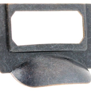 May include: A black metal drawer pull with a rectangular label holder and a curved handle. The label holder has a beveled edge and a slightly raised lip.